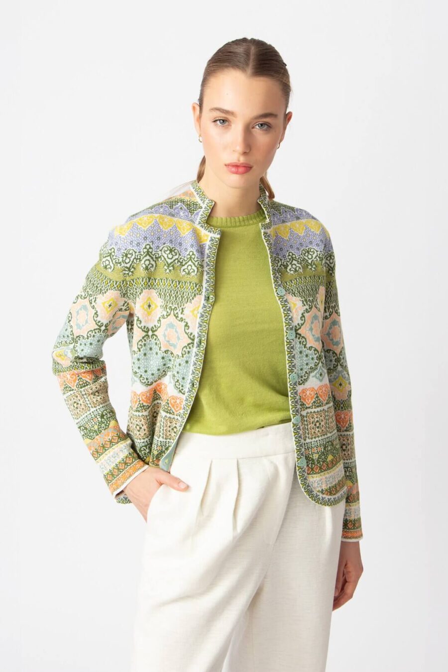 Model draagt groen IVKO vest met Morocco-patroon en groene top, frisse voorjaarslook.