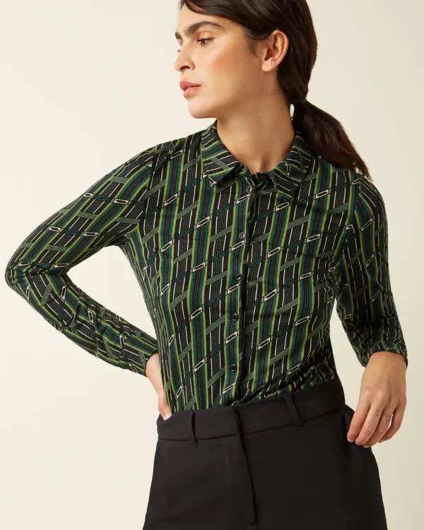 Model draagt King Louie Blouse Brina in retro groen motief, voorkant zichtbaar