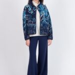 Model draagt een blauw Ivko vest met kilim motief, open gedragen over een witte coltrui en gecombineerd met donkerblauwe wijde broek.