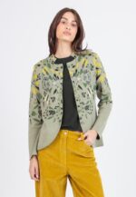 Model draagt een groen Ivko vest van 100% katoen met Plantopia botanische print, gecombineerd met mosterdgele corduroy broek.