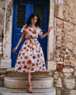 Model draagt Ivko blouse met floral pattern in warme tinten oranje, blauw en zand