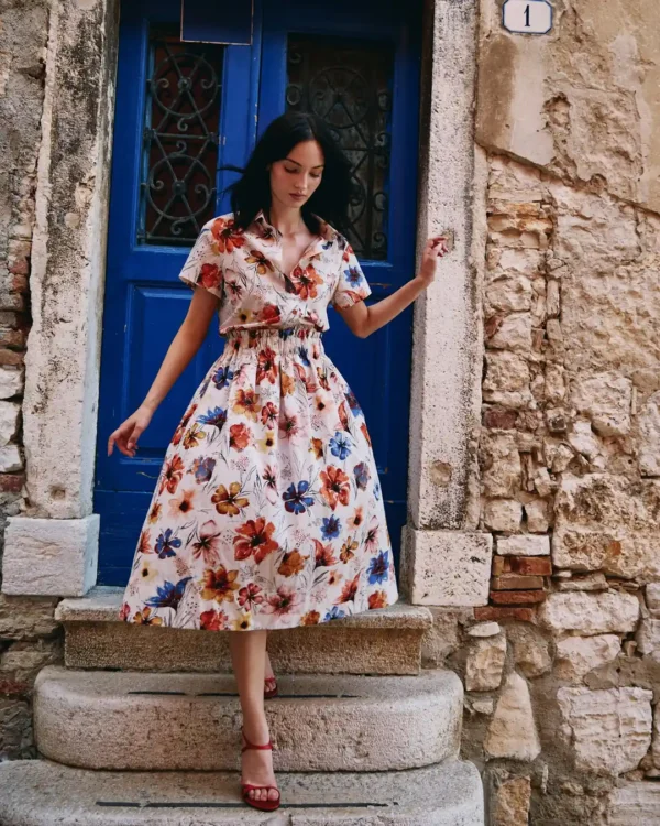 Model draagt Ivko blouse met floral pattern in warme tinten oranje, blauw en zand