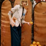 Model draagt Ivko vest met bloemenprint gecombineerd met donkerblauwe broek