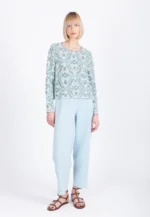 Model draagt Ivko jacket Ornament in wit en groen met lichtblauwe broek
