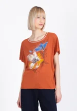 Model draagt Ivko T-shirt Floral Pattern in roest met kleurrijke bloemenprint