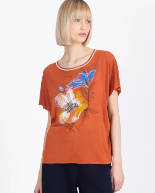 Model draagt Ivko T-shirt Floral Pattern in roest met kleurrijke bloemenprint